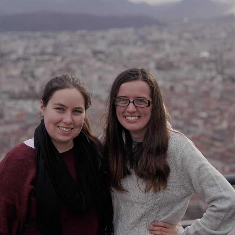 Two students with a cityscape in the background.