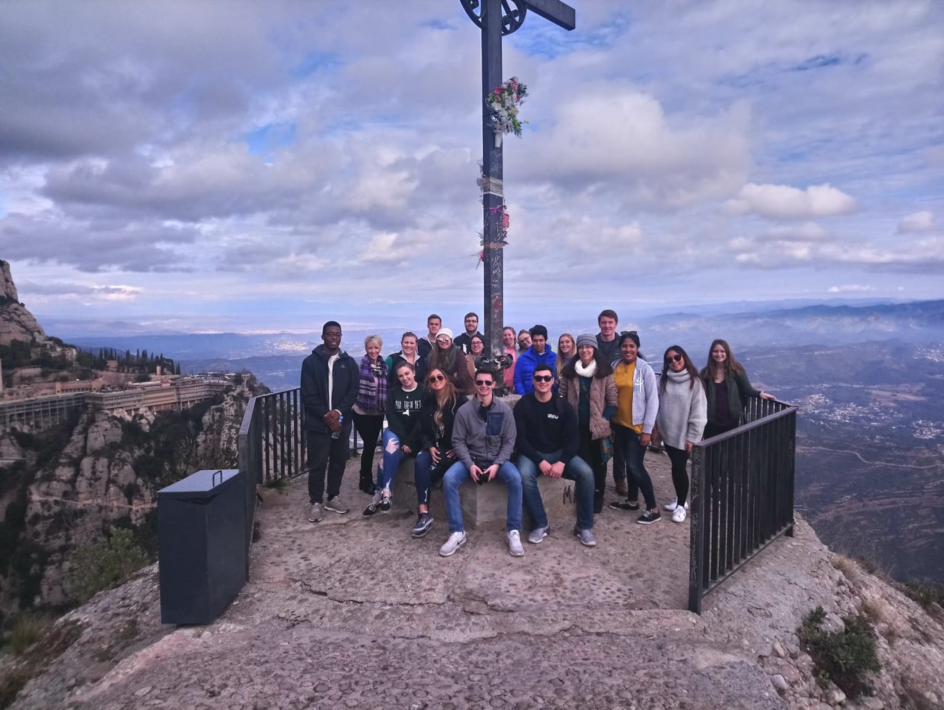 Group posing in front of pole.