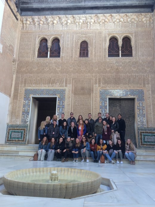 People posing in group in front of building.