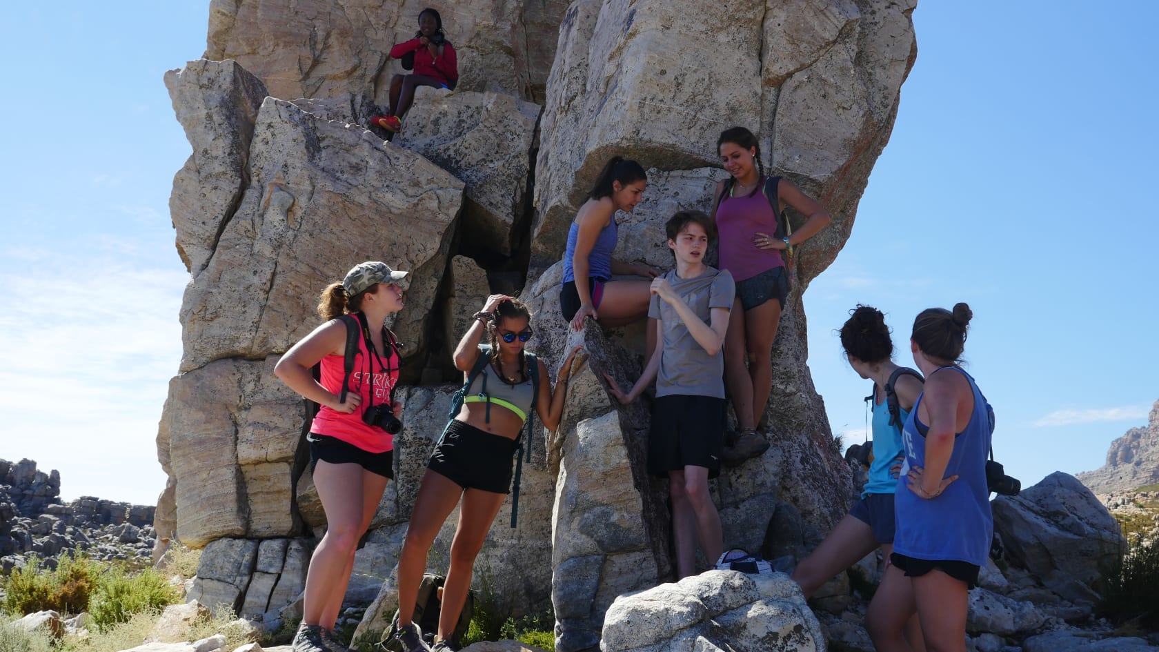 Kids posing in front of rock.