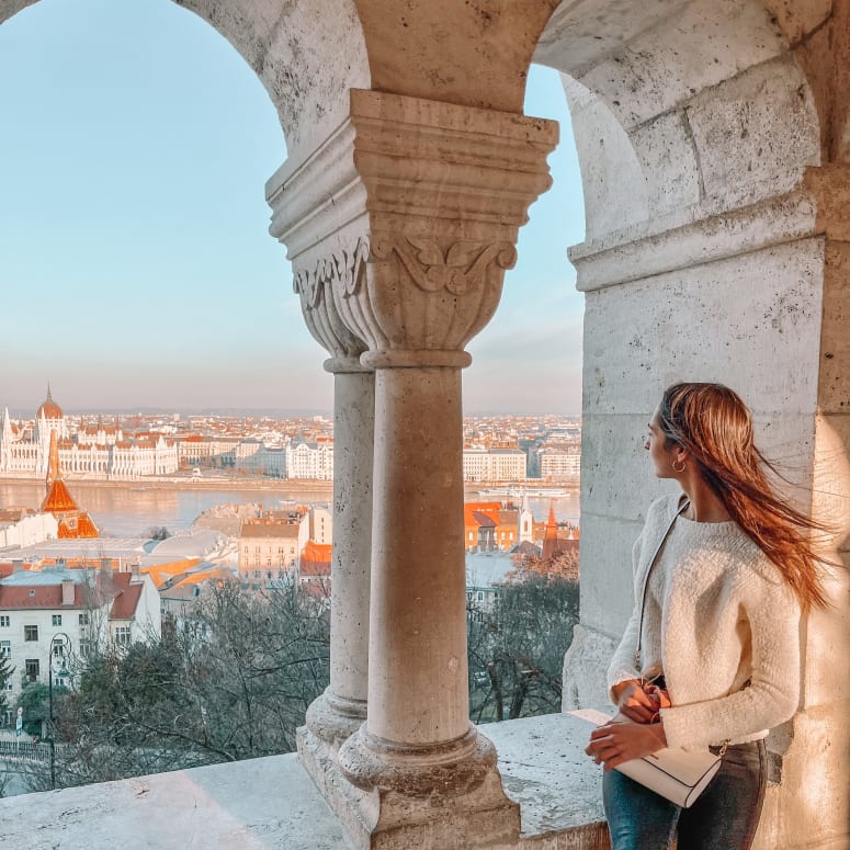 A student looking out towards a view of Budapest.