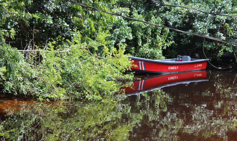 A red boat on a river.