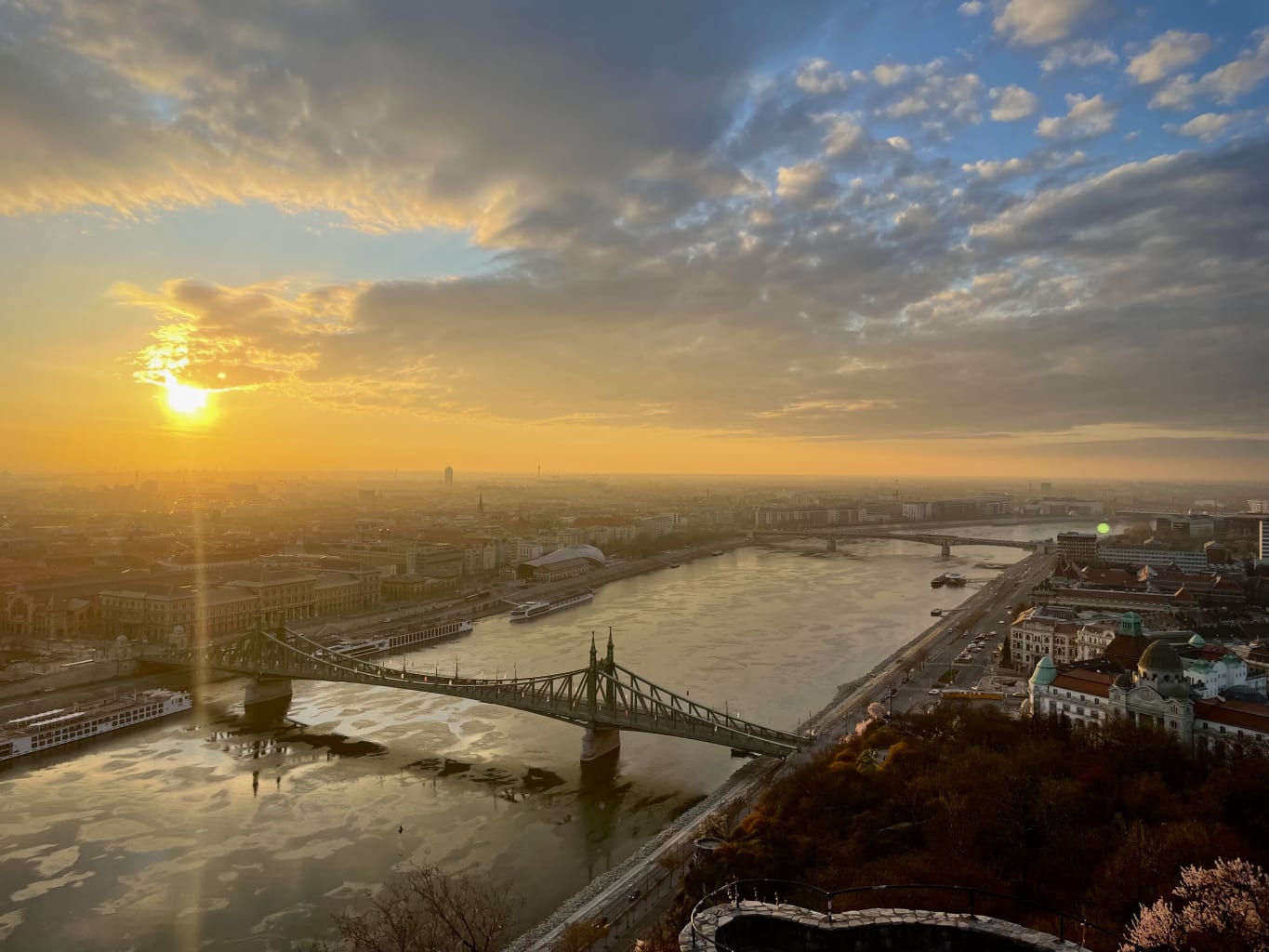 An aerial view of a city with a sunset in the background.