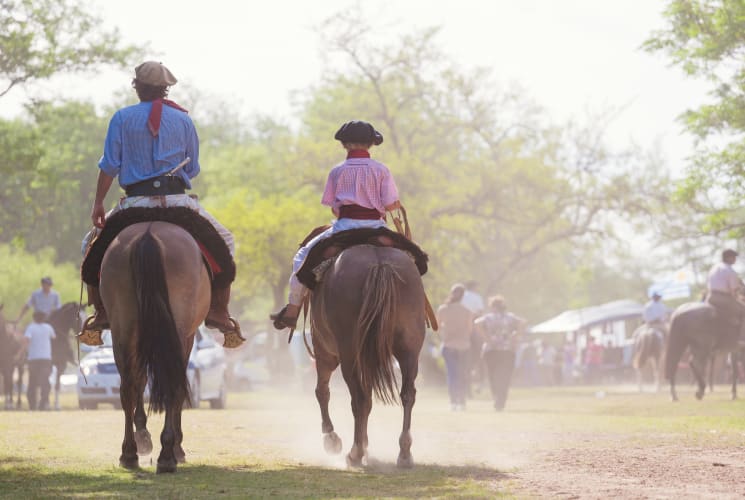 Two people riding horses.