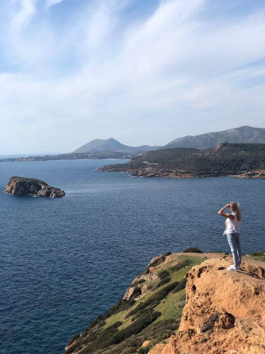 A student standing on a cliff overlooking the ocean.