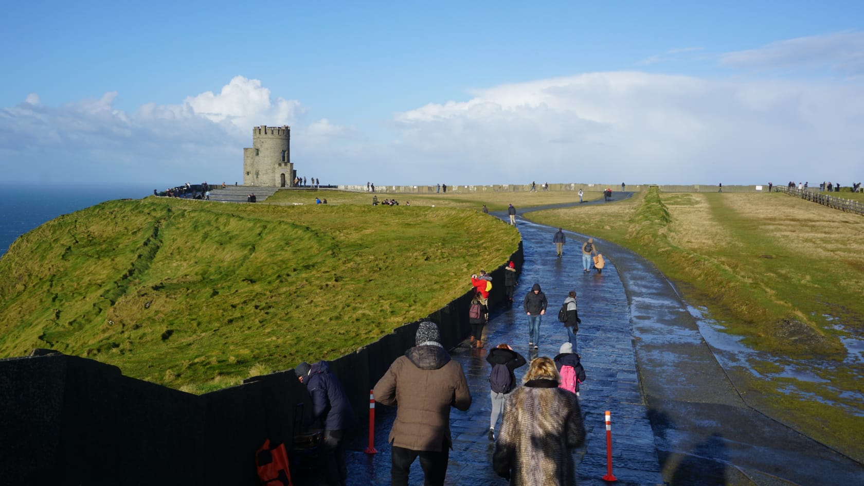 Students walking down a path on a cliff overlooking the ocean in Ireland.