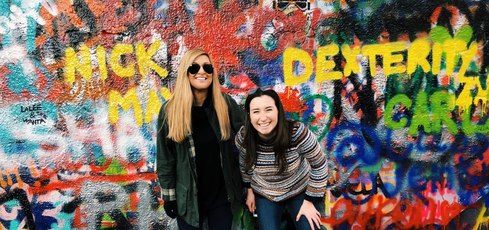 Girls in front of wall.