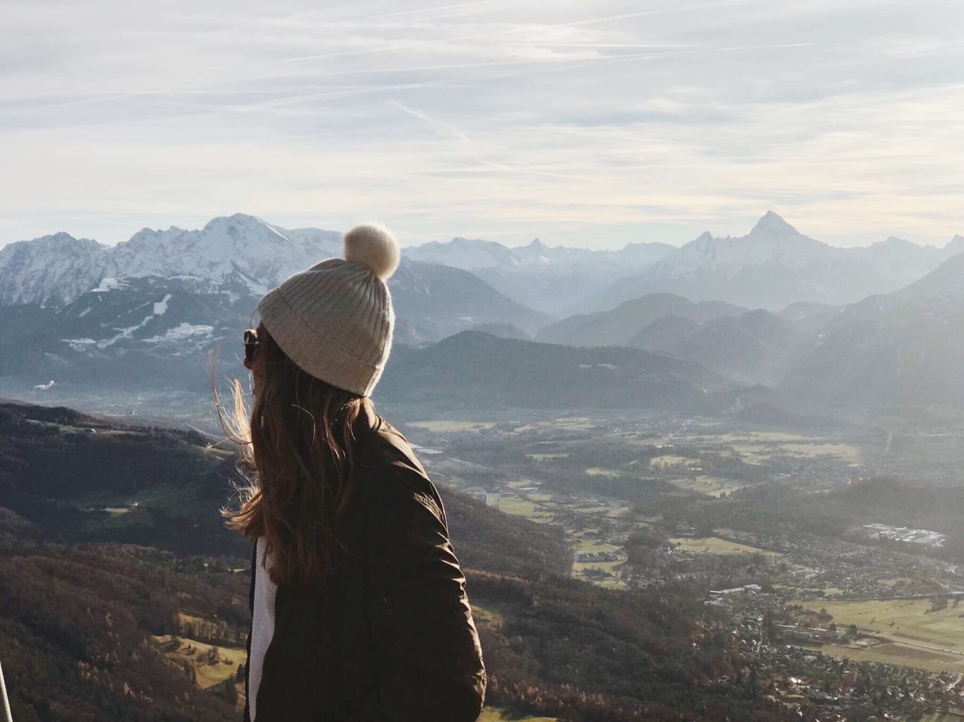 Girl looking behind her shoulder at mountains.