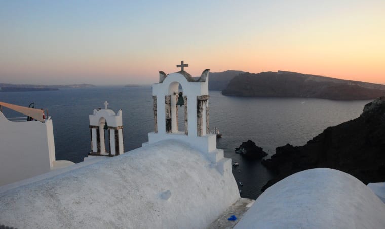 A white building overlooking the ocean in Greece.