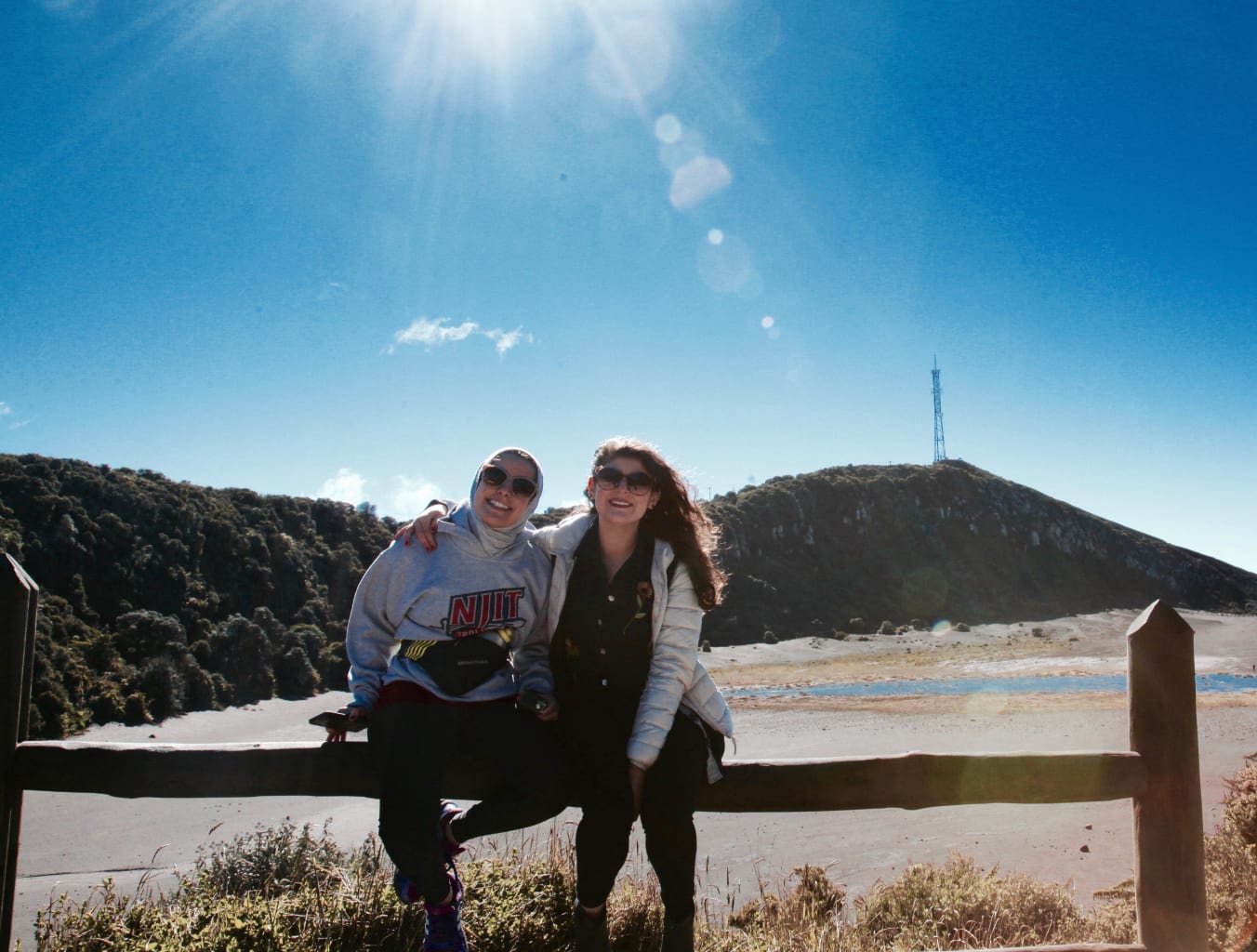 Two students sitting on a fence.