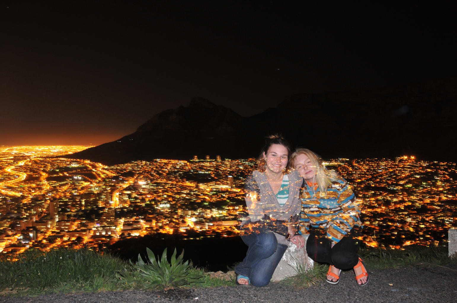 Girls posing in front of night lights.