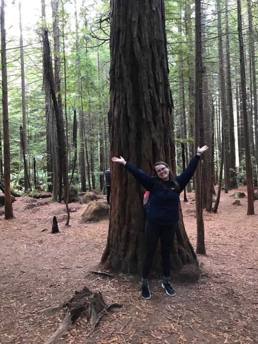 Girl posing in front of a tree.